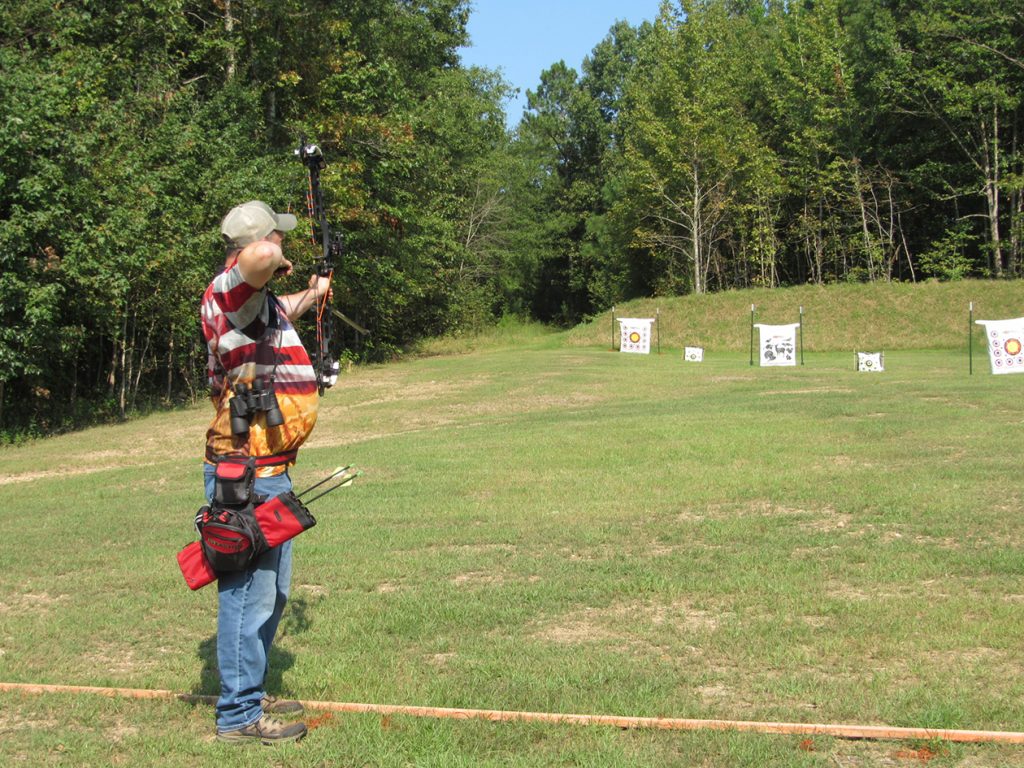 Competitor aiming arrow at CMP Talladega Archery Range.