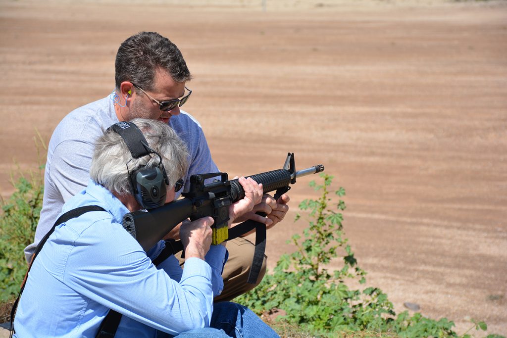 Firearm instructor with student on firing line