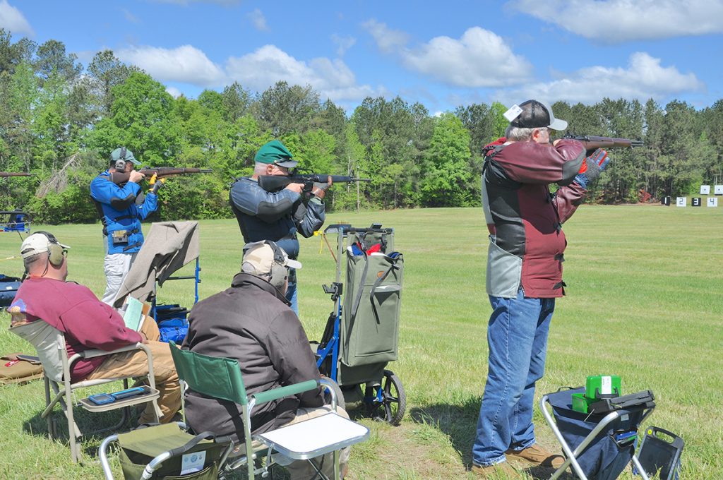 Vintage rifle competitors aiming downrange