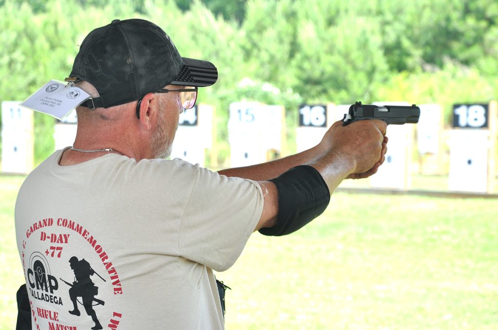 Competitor firing a pistol at target.