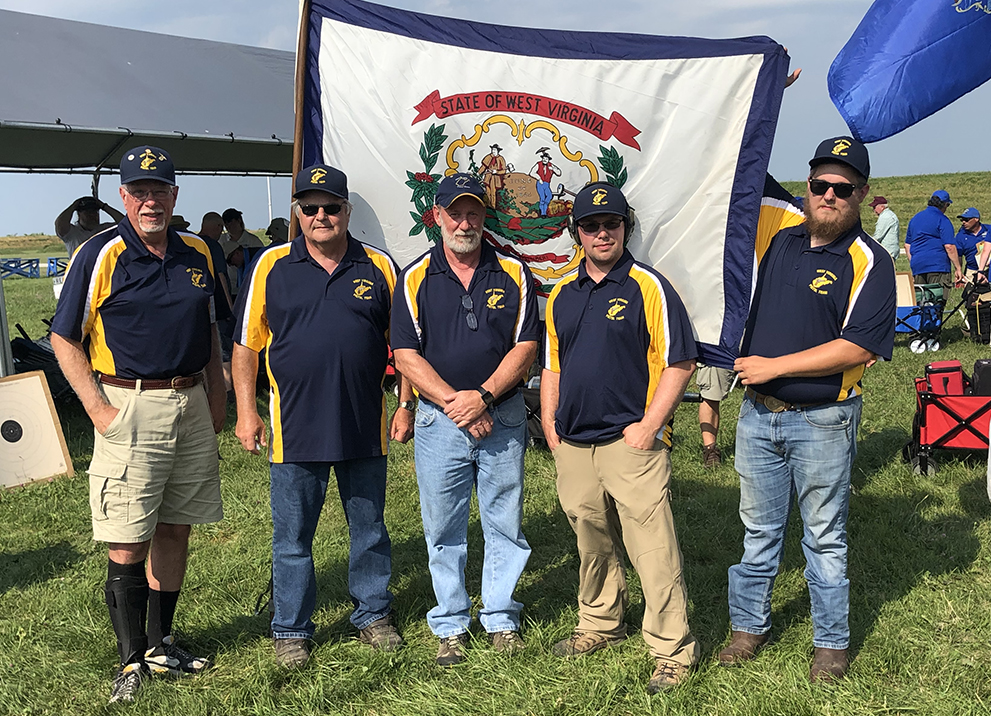 West Virginia pistol team poses for a photo with flag