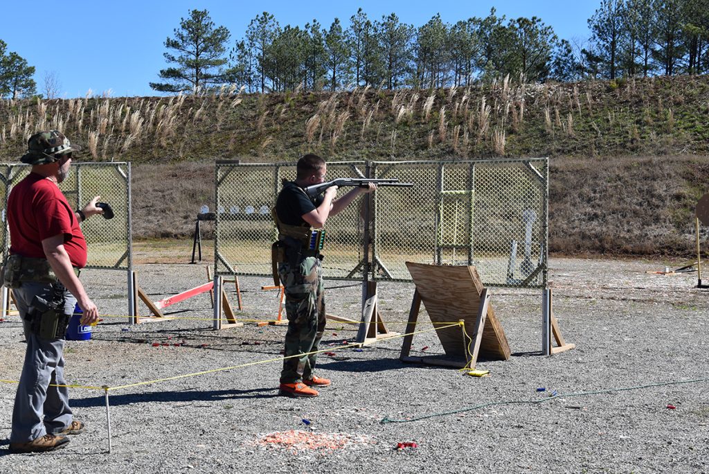 3-gun competitor aiming at target