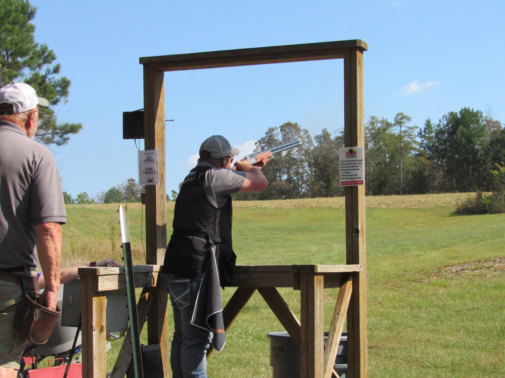 Shotgun competitor aiming at clay