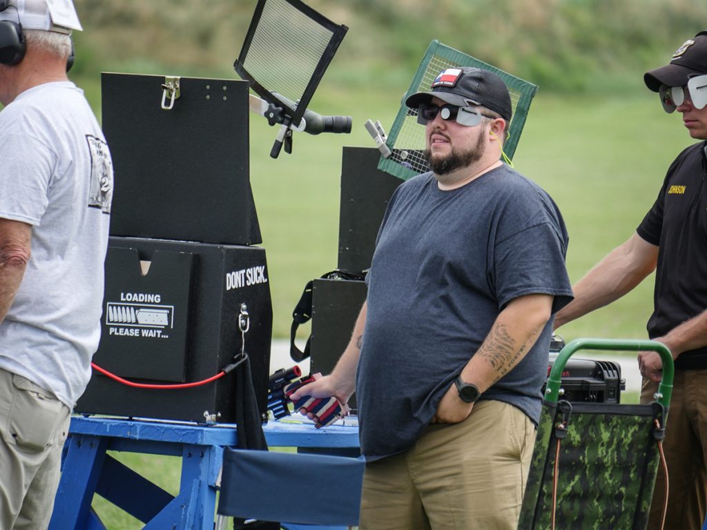 A pistol athlete pauses between shots to set up for his next round. 