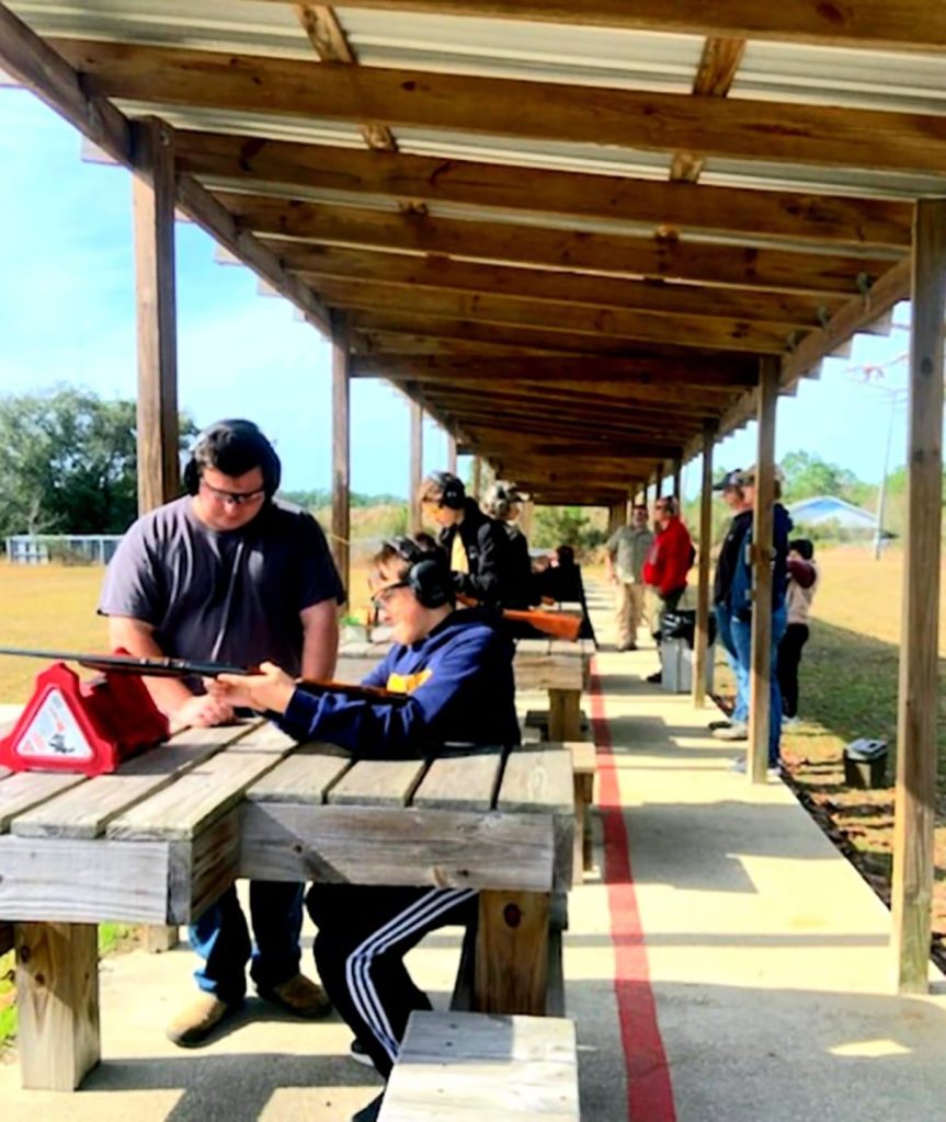 Boy scout on range receiving instruction.