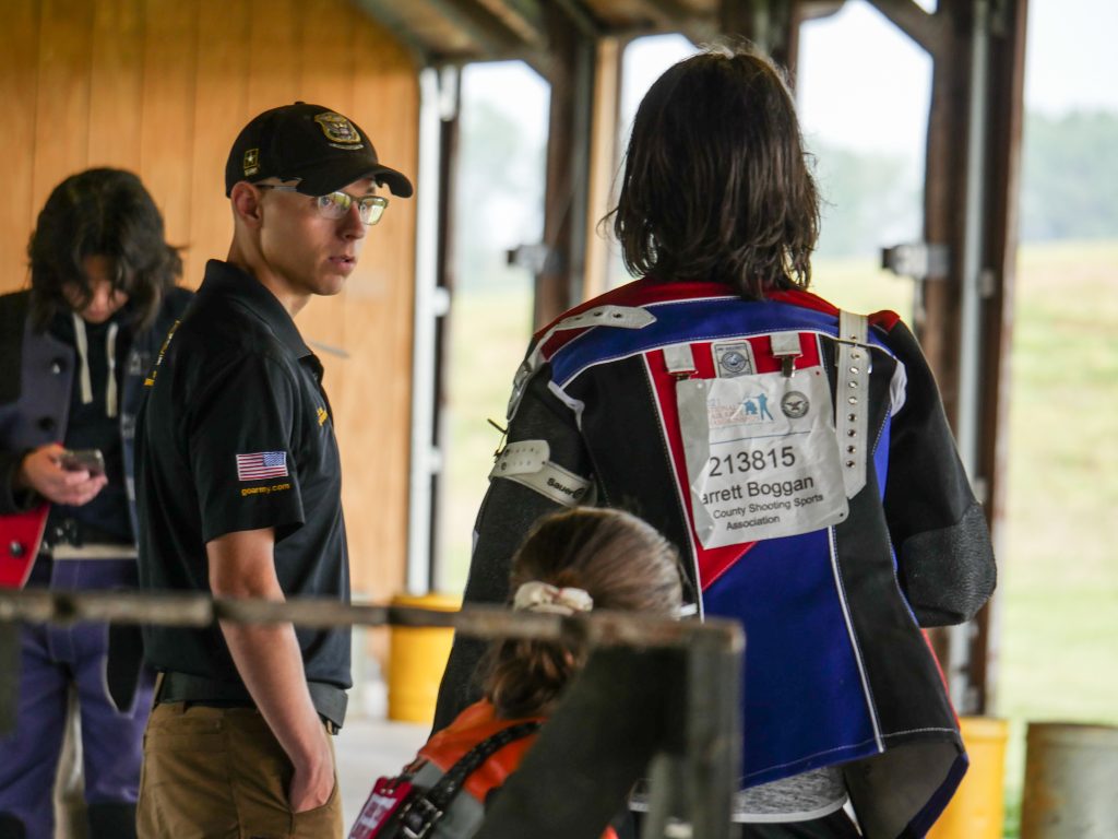 Spc Roe teaching junior competitors on the firing line.