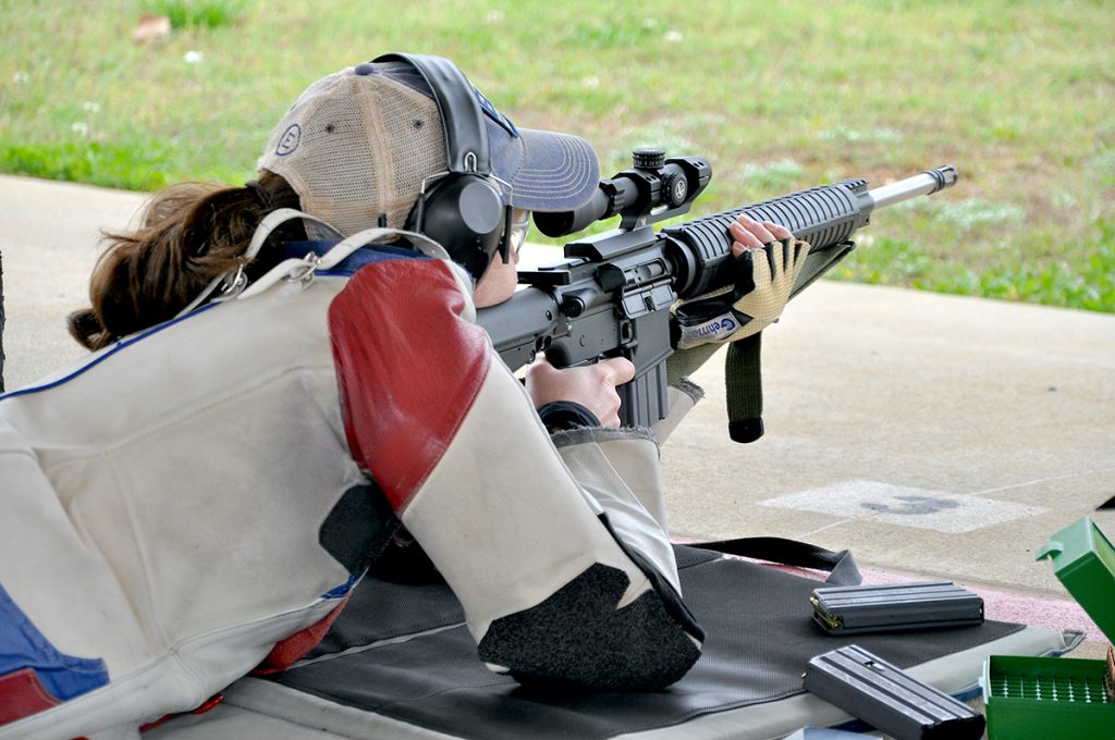 Prone rifle competitor aiming downrange.