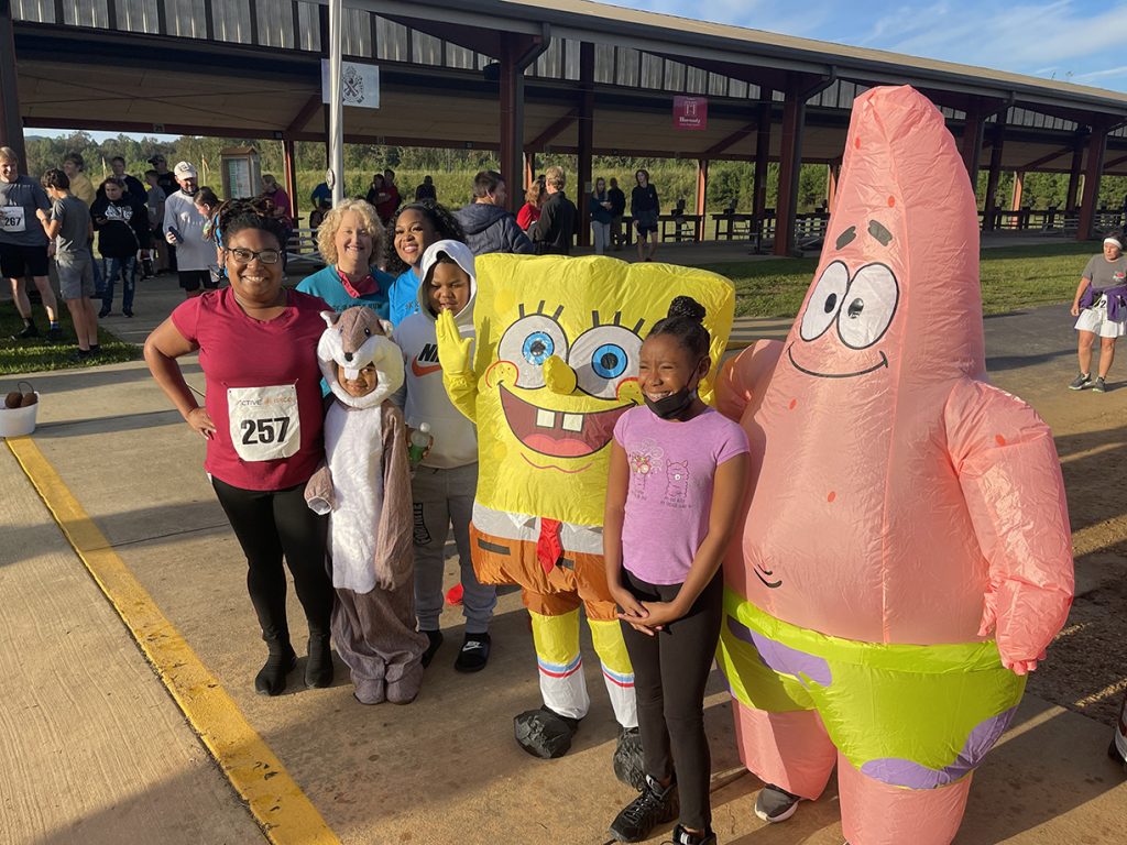 Family poses after the race with Spongebob and Patrick after the race.