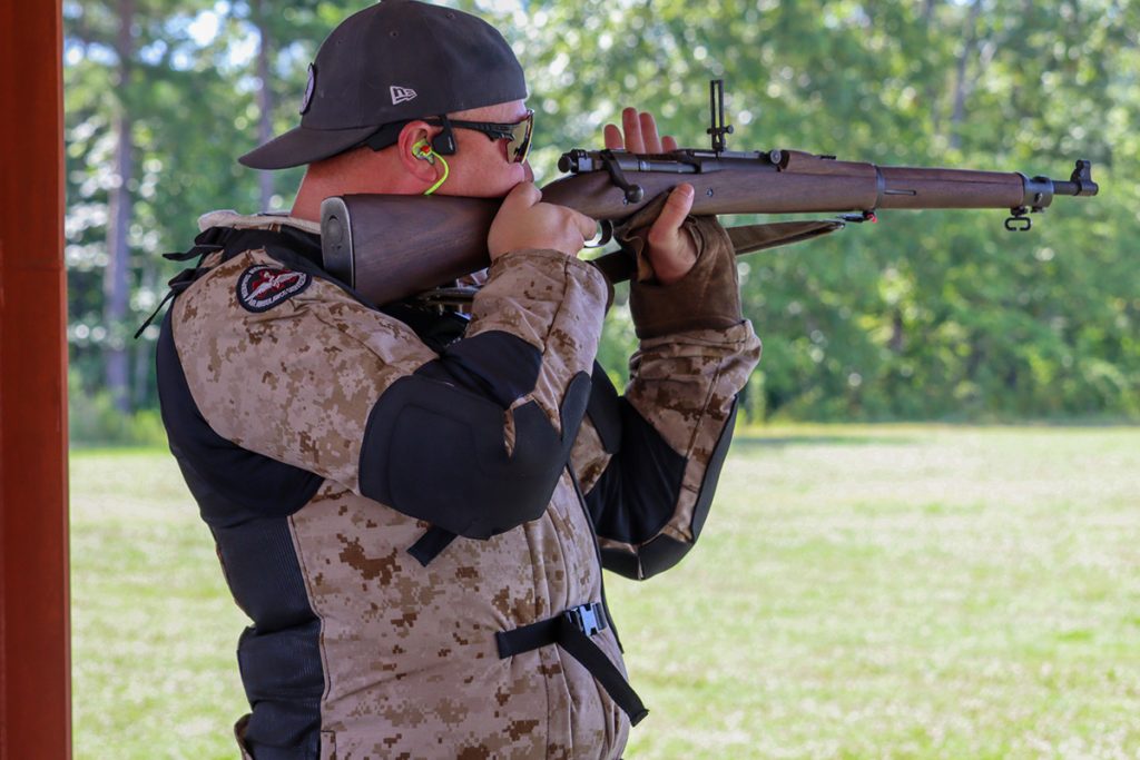 Competitor aiming vintage rifle downrange.