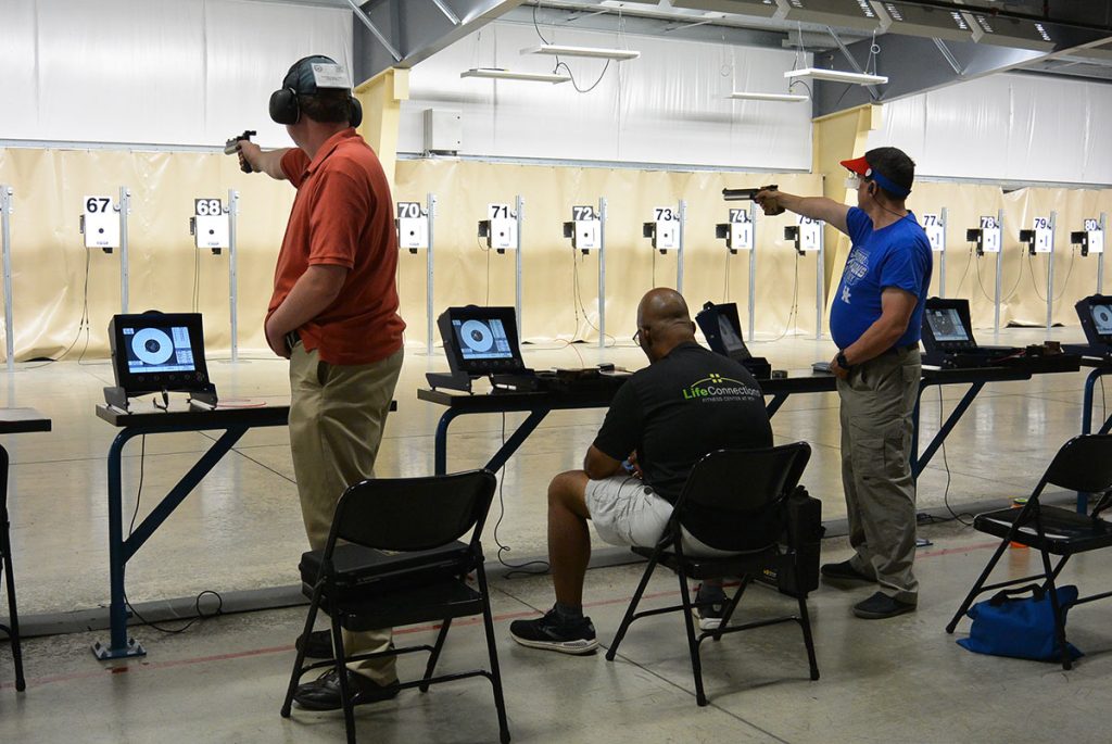 Pistol competitors taking shots at targets