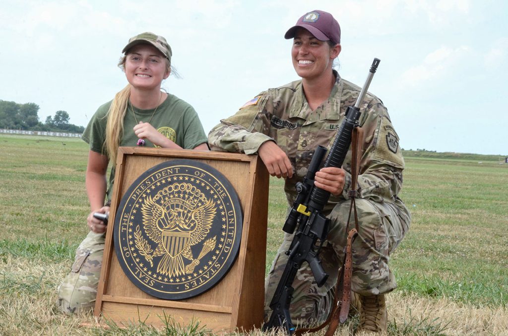 SSG Elsenboss poses with the President's Rifle Trophy and another female competitor.