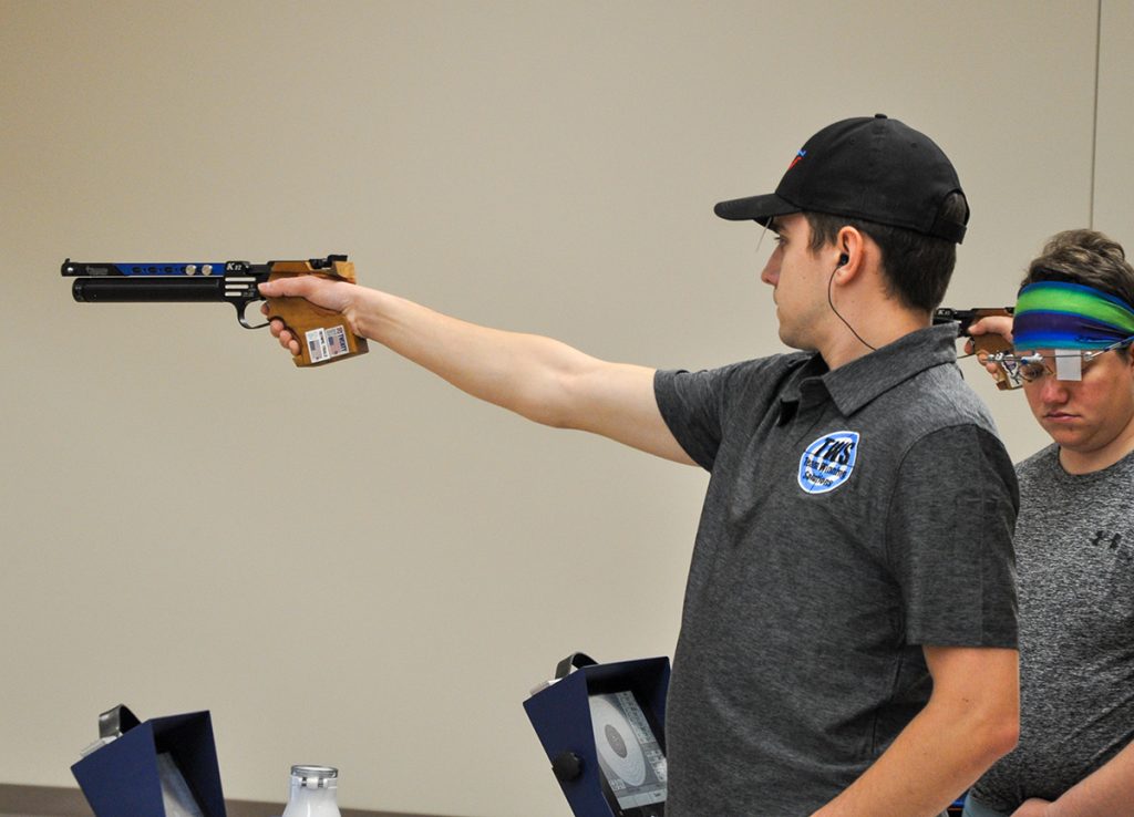 Pistol athlete aiming downrange.