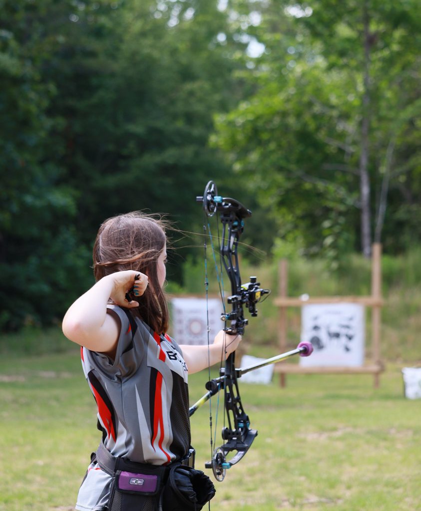 An archer standing on the pratice range, having just released an arrow.