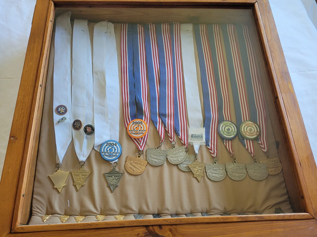 Additional rimfire medals belonging to Rex, also displayed in a glass case.