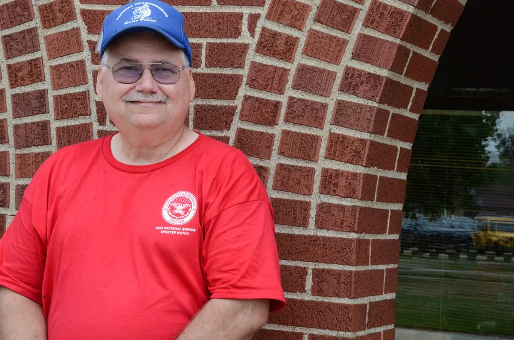 Rex Walter standing outside against a brick wall at Camp Perry.