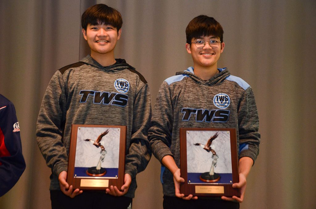 Tyler and Ryan stand together on the podium holding their awards for the Freedom's Fire match.