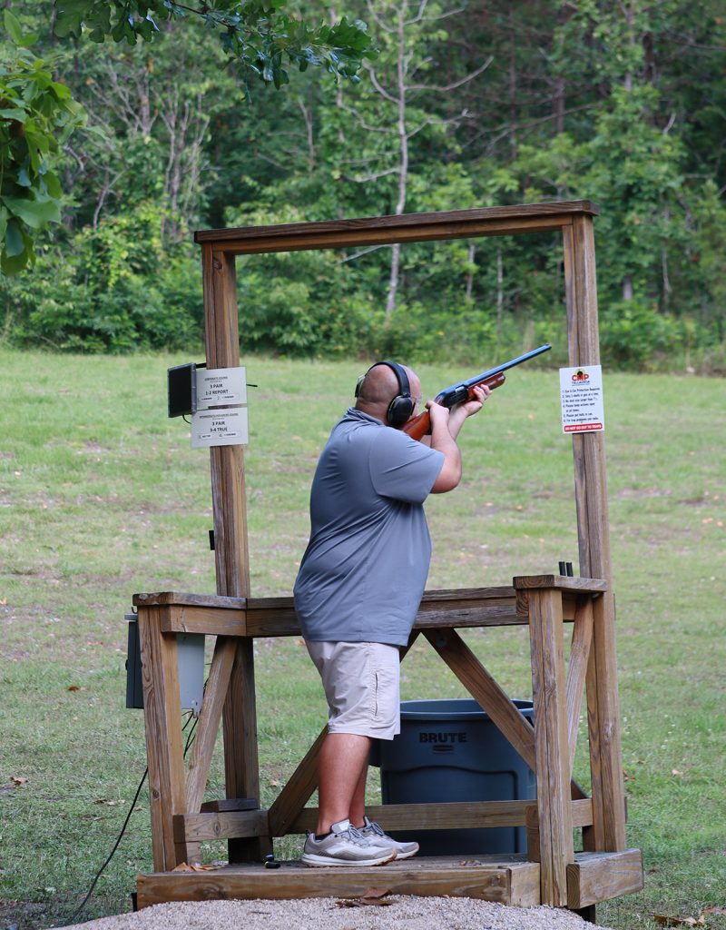 A man shooting from a sporting clays stand.