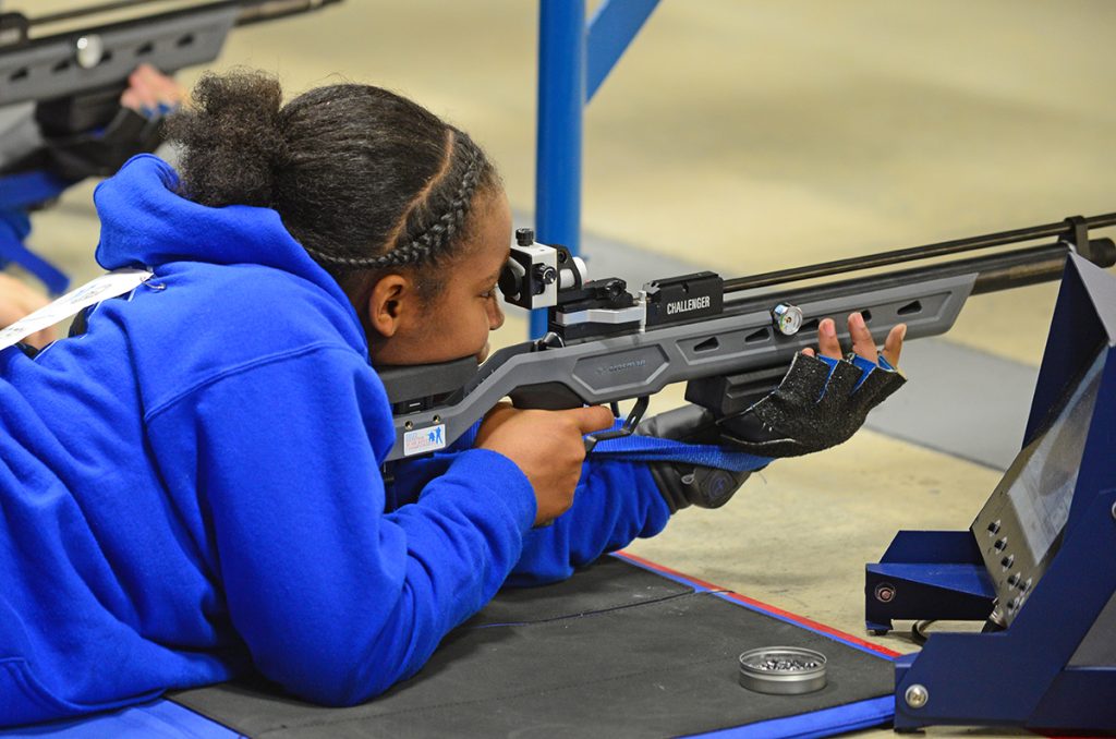 A female sporter athlete shooting the new Crosman CH2021 air rifle in the prone position.