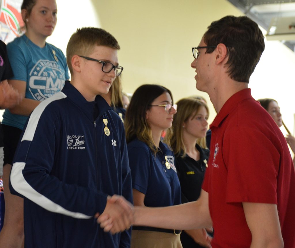 A junior rifle athlete receiving his Junior Distinguished Badge.