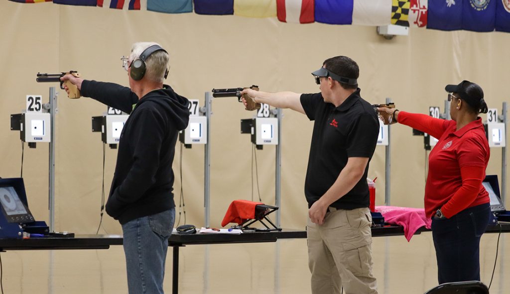 Pistol competitors aim at their targets during the match.