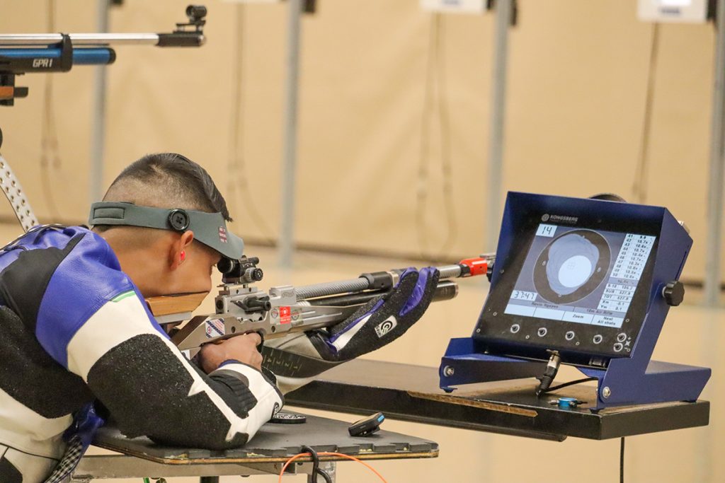 A Para-athlete aims downrange in a support position.