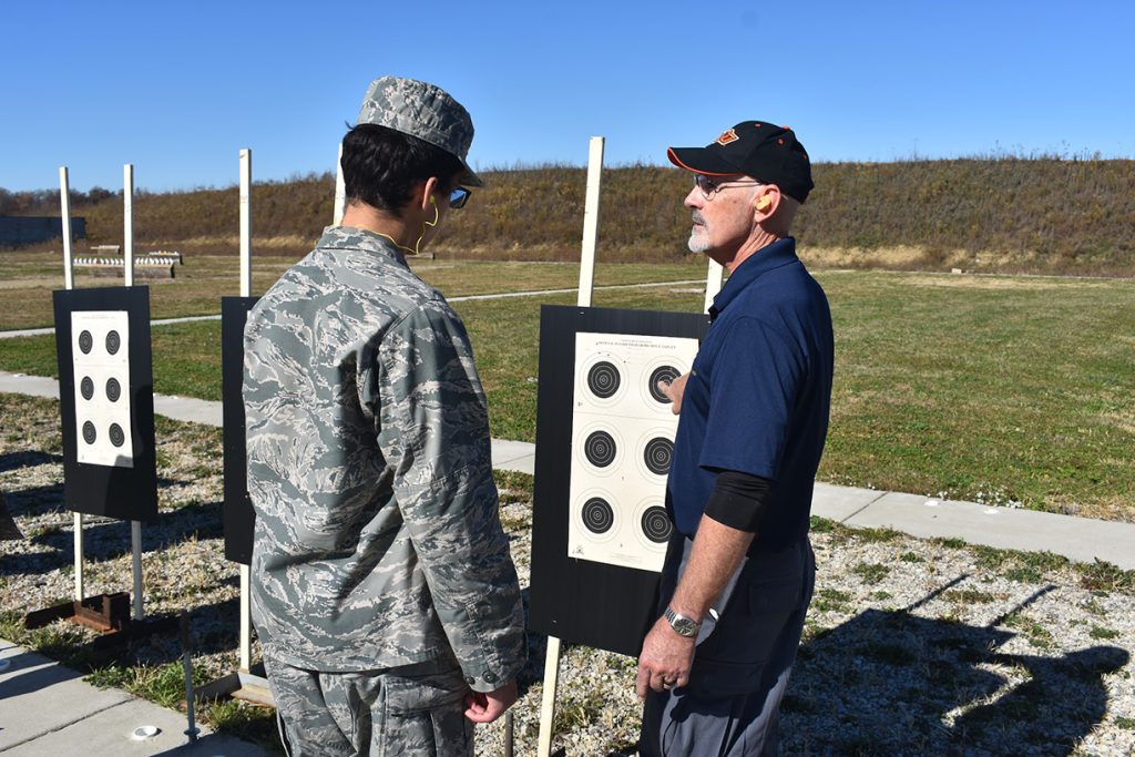 Dan Arnold and a cadet stand at the targets, and evaluate shot groups.