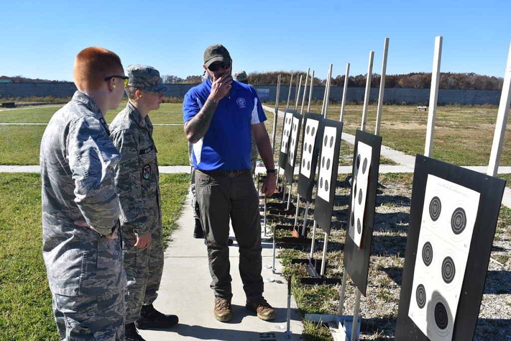 Dean Bates evaluating shot groups on the targets with two cadets.