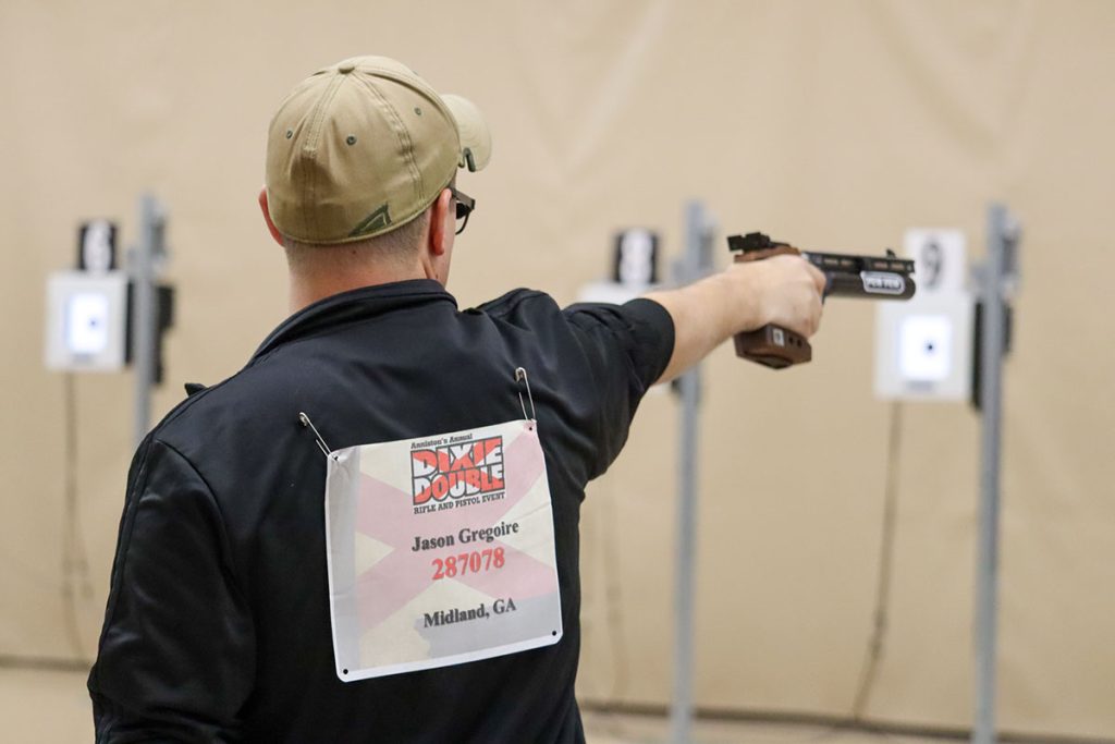 SPC Jason Gregoire aiming his air pistol downrange.