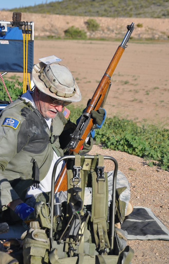 Competitor holding rifle on firing line.