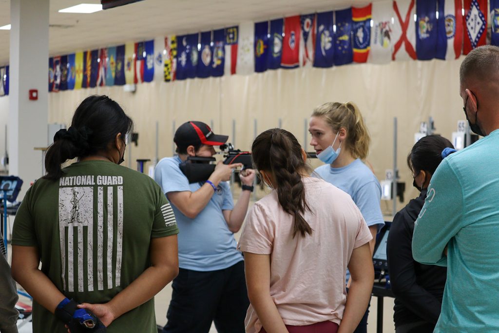 College rifle athletes give a demonstration on the firing line to junior camp participants.