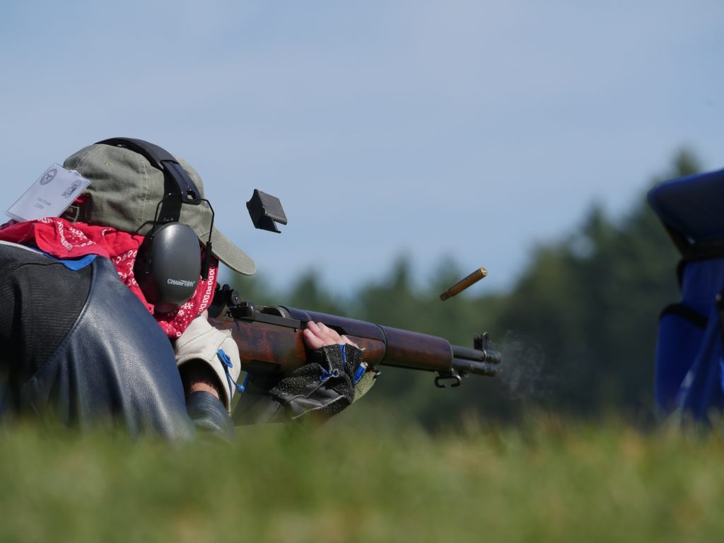 A competitor firing an M1 Garand rifle in the prone position.