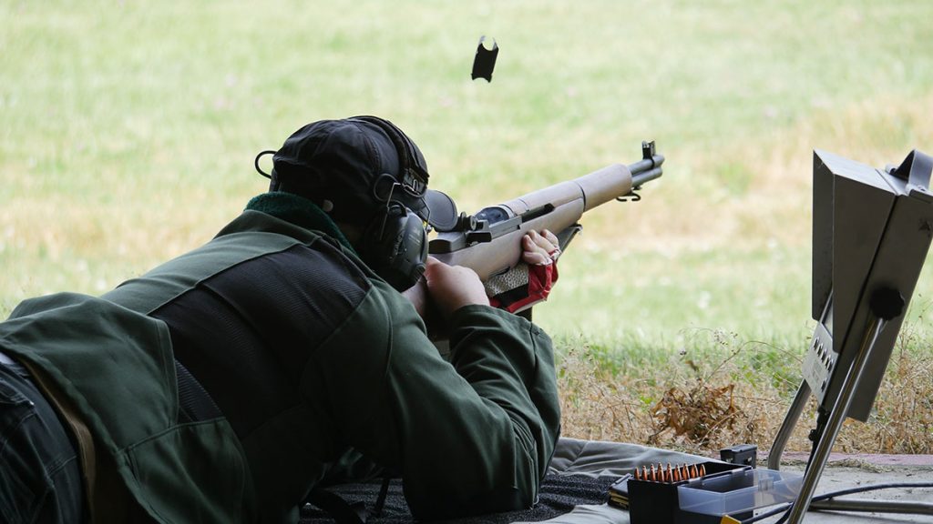 A man firing a rifle on a range