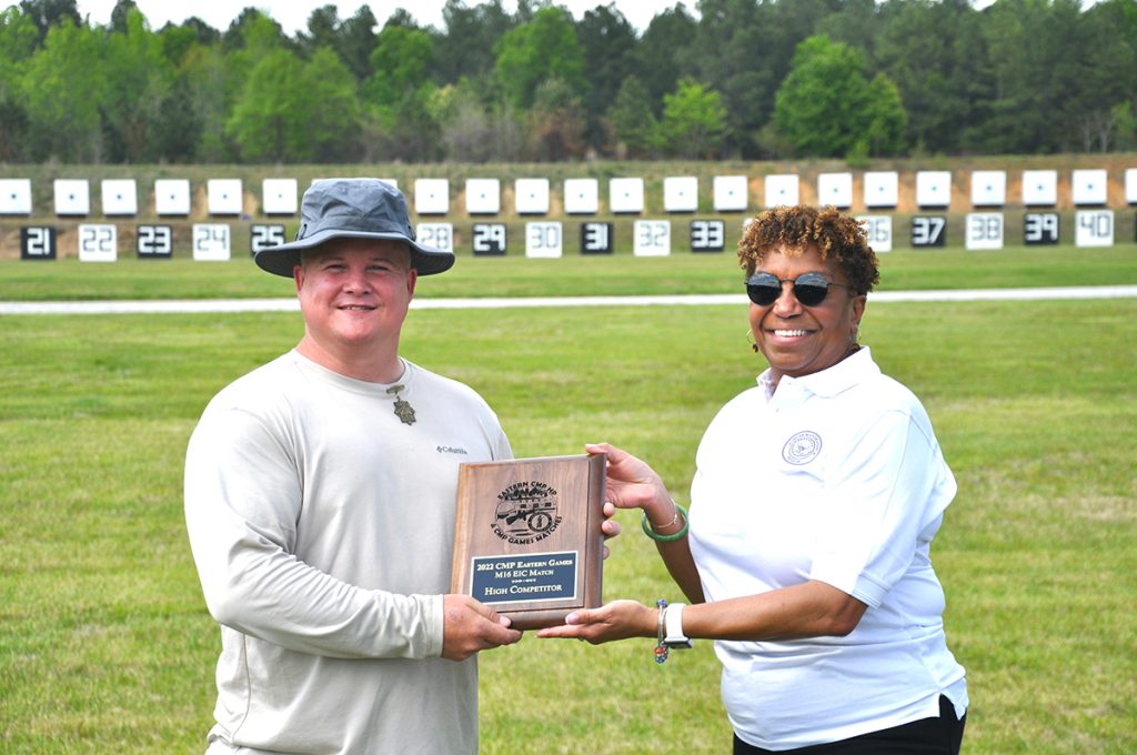 A competitor being presented with a trophy on the range.