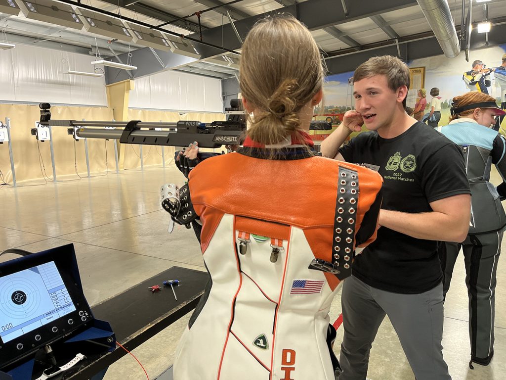Ryan Hinson instructing an air rifle shooter on the line. He is demonstrating cheekpiece contact for the standing position.