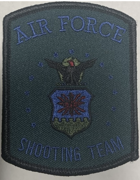 The second version of the United States Air Force Shooting Team logo patch. The patch is a dark green, with blue lettering reading 'Air Force Shooting Team.' A blue circle of small stars surrounds the same logo as the original patch in much darker colors.