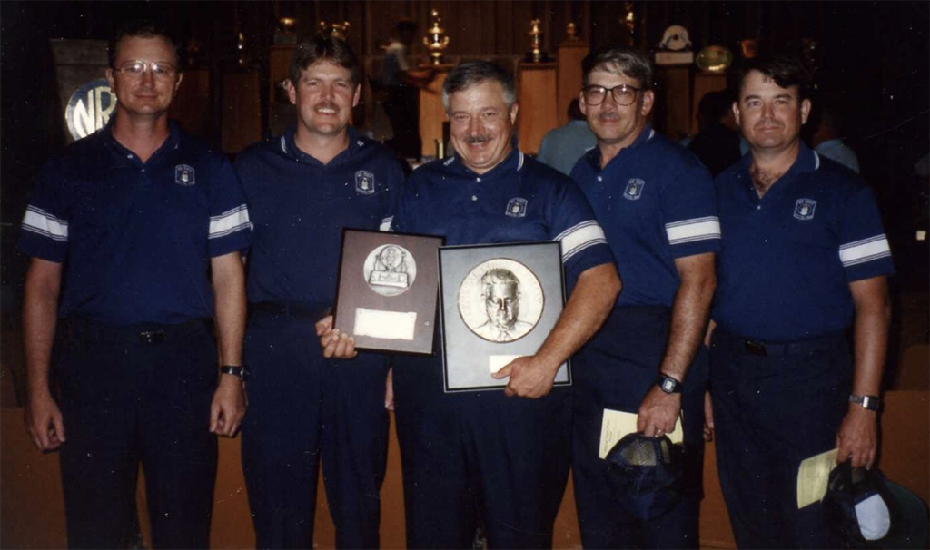 Doc Engelmeier, holding the LeMay and Spaatz awards, posing with teammates.
