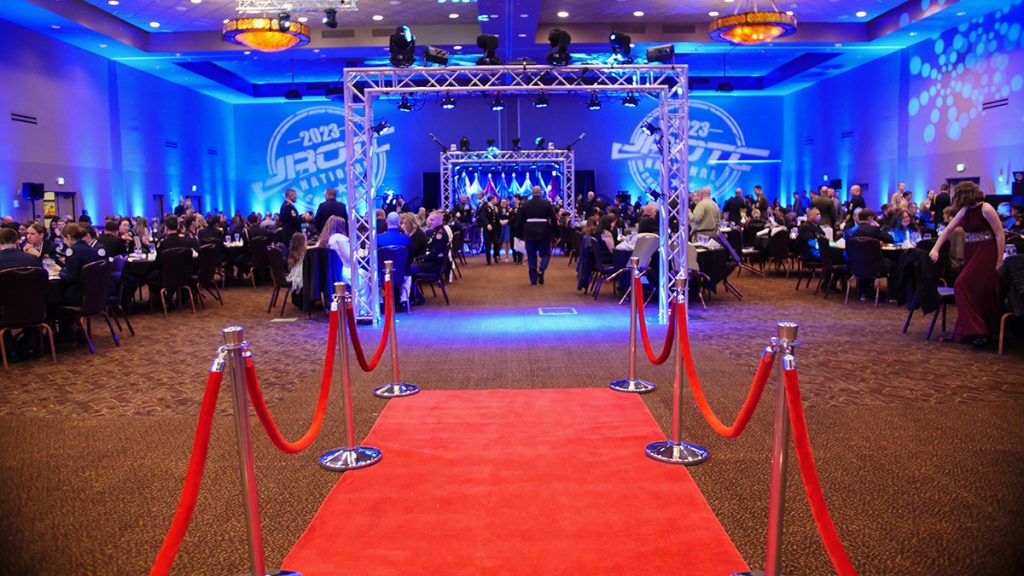 A photo of the awards banquet setup, featuring a red carpet and lighting displays.