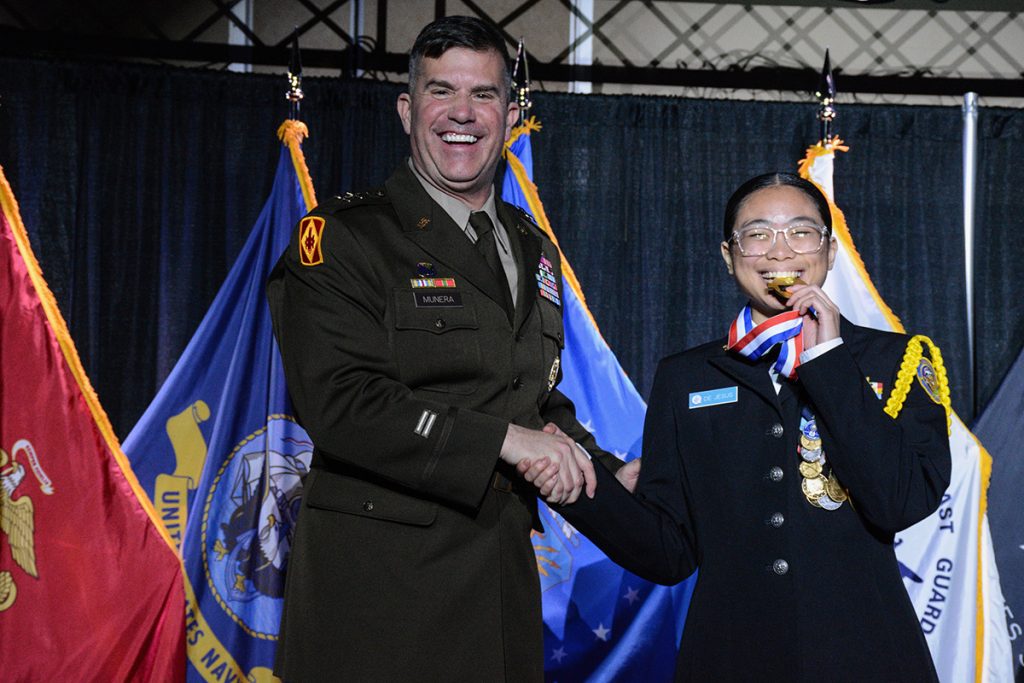 Danjela de Jesus receiving her gold medal on stage.