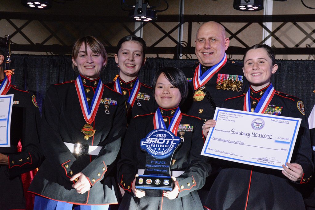 Granbury High School on the podium with their medals, trophy, and check prize.