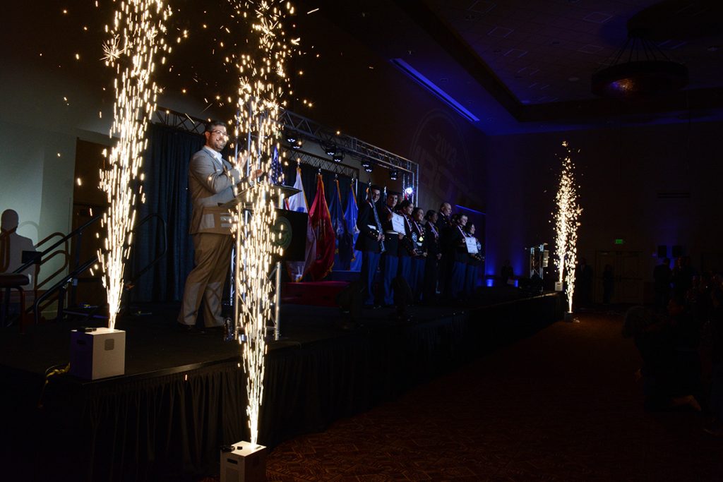 The National Champion teams and individuals on stage while sparklers go off on each side.