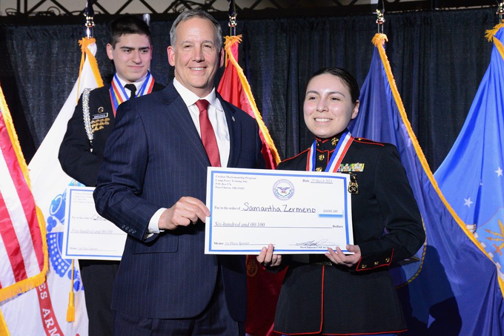 Samantha Zermeno receiving her gold medal and check prize on stage.