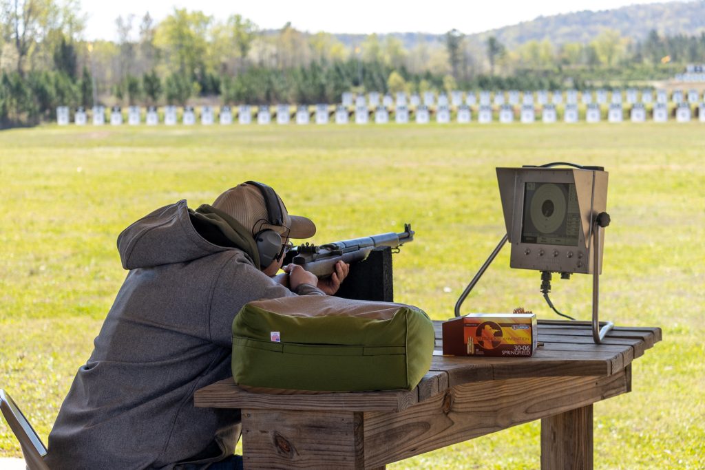 A guest competing with a rifle in the benchrest position at CMP's Talladega Marksmanship Park.