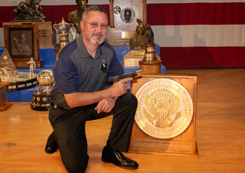 John Bicker poses with trophy and his pistol.