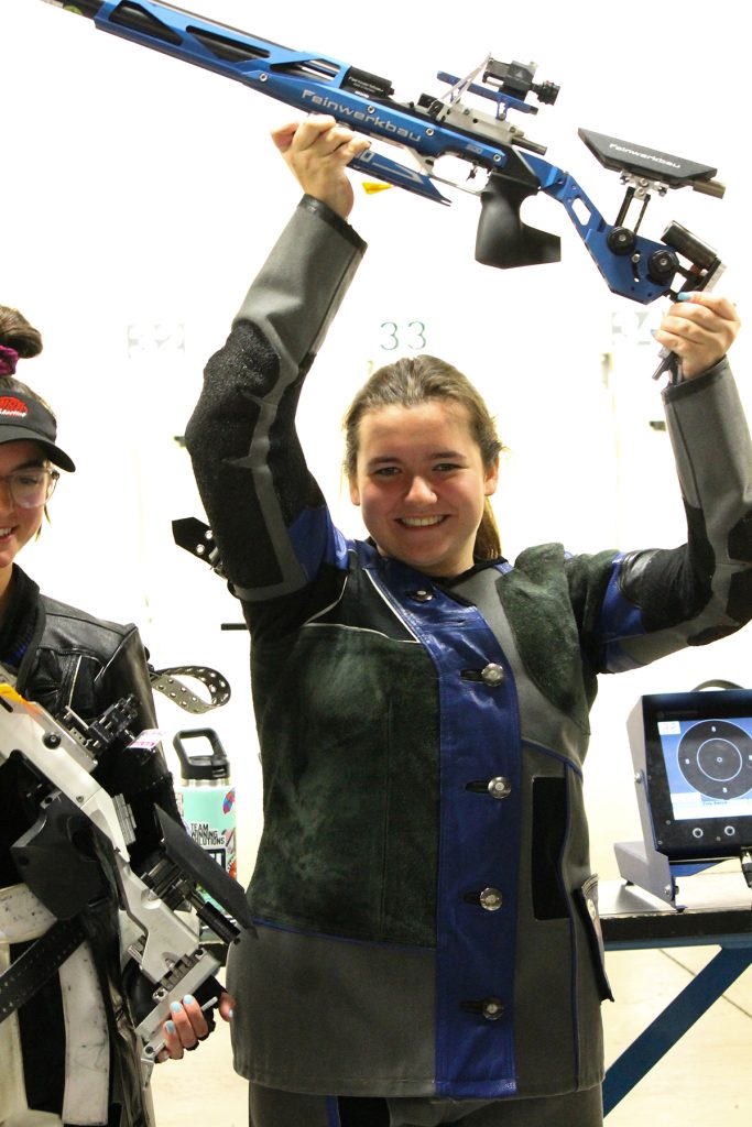 Makenzie holds rifle over head celebrating win