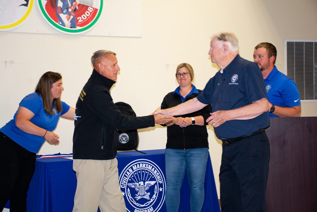 Col Mulcahy shakes hands with CMP staff members.