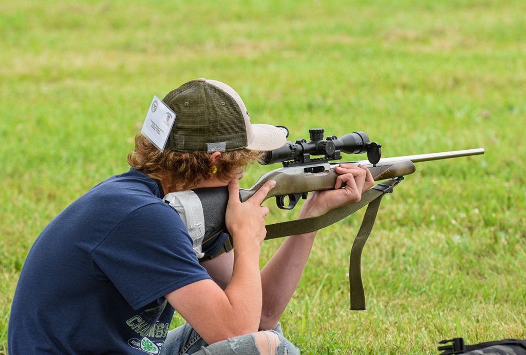 Competitor in kneeling position firing at target.