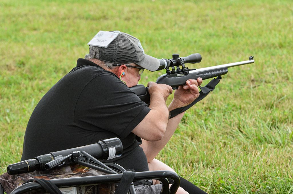 Competitor in kneeling position firing at target.