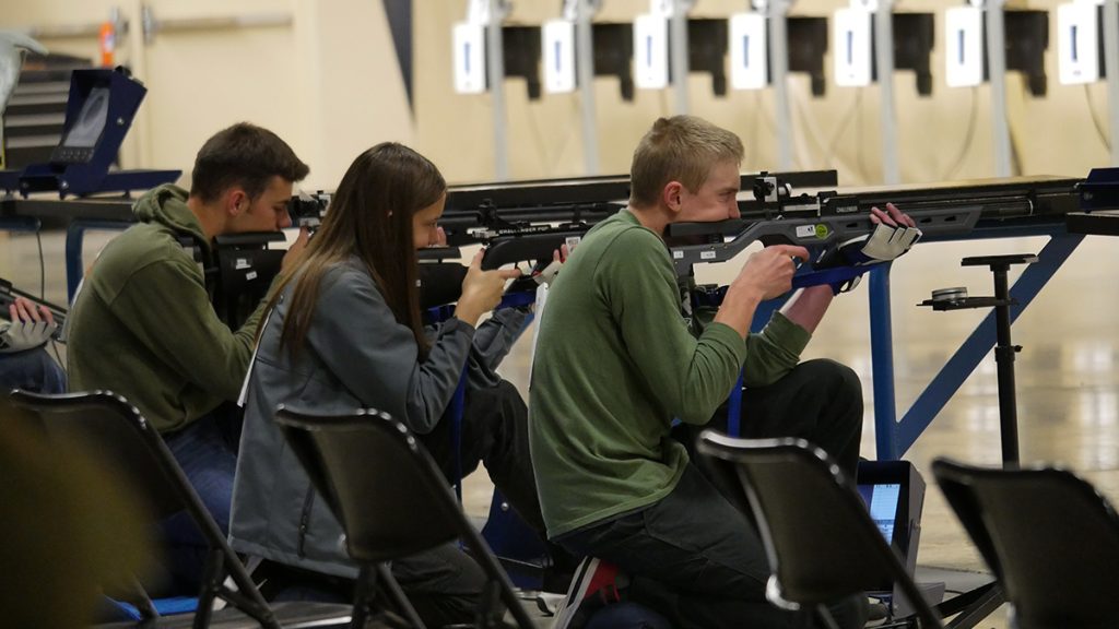 Sporter air rifle competitors in the kneeling position.