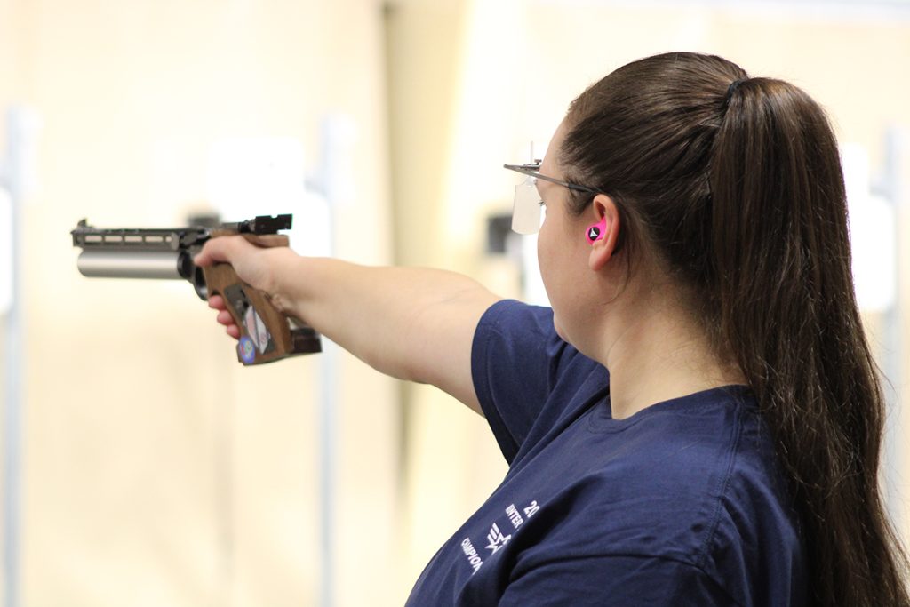 Emmert Traciak firing a pistol downrange.