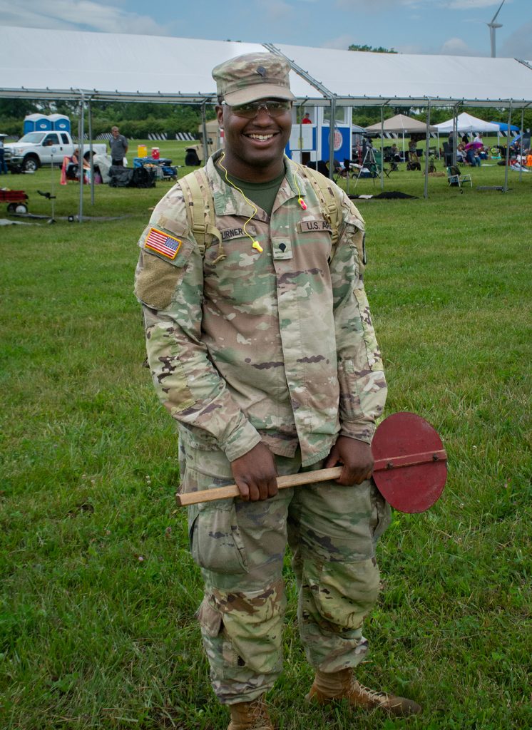 A soldier with red paddle on the firing line.